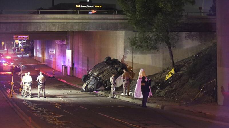 Agentes de la patrulla de caminos de California trabajan en la escena de un accidente de auto...