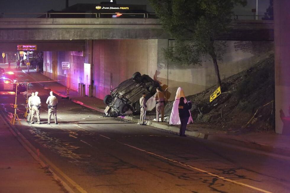 Agentes de la patrulla de caminos de California trabajan en la escena de un accidente de auto...