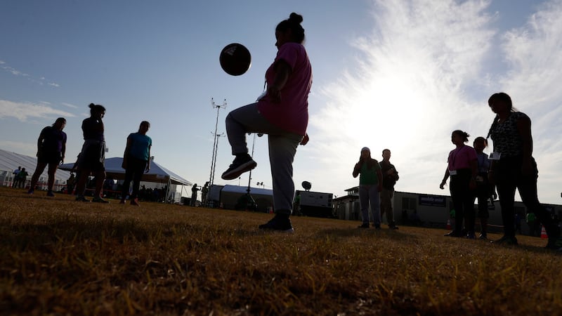 ARCHIVO - Personas juegan fútbol en un centro de detención del gobierno de EE.UU. para niños...