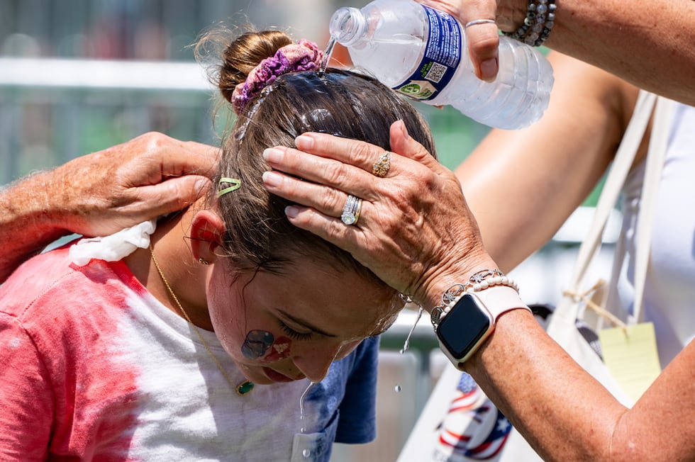 ARCHIVO - Ruth, de 11 años y originaria de Burke, Virginia, recibe agua fría sobre la cabeza...