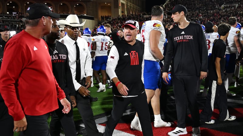 El entrenador de Texas Tech, Joey McGuire, en el centro, habla con el entrenador de Kansas,...