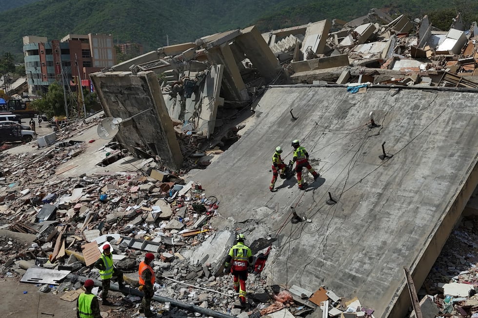 Equipos de rescate del Ejército mexicano buscan a personas atrapadas en edificios derrumbados...