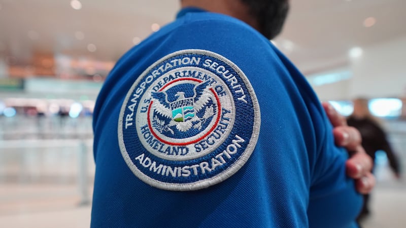 Un agente de la TSA con un parche del Departamento de Seguridad Nacional en su uniforme en el...