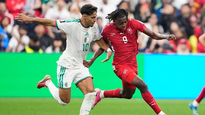 Johan Manzambi, de la selección de Suiza, conduce un balón frente a Fares Chaibi, de Argelia,...