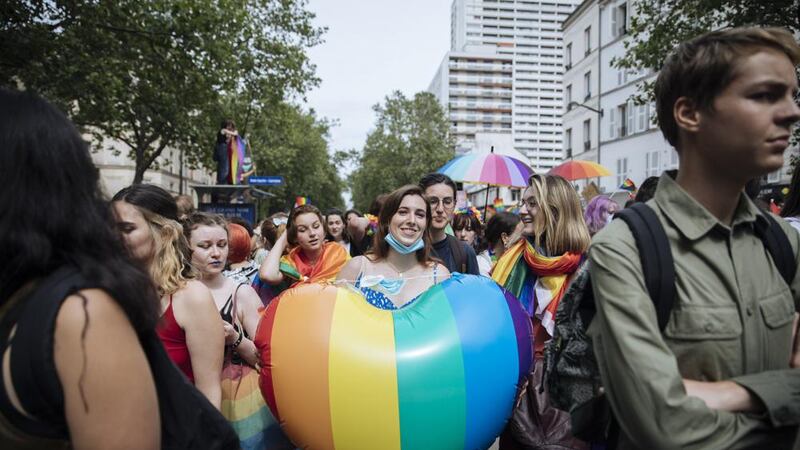 En esta imagen de archivo, una participante sostiene un corazón con la bandera arcoiris...