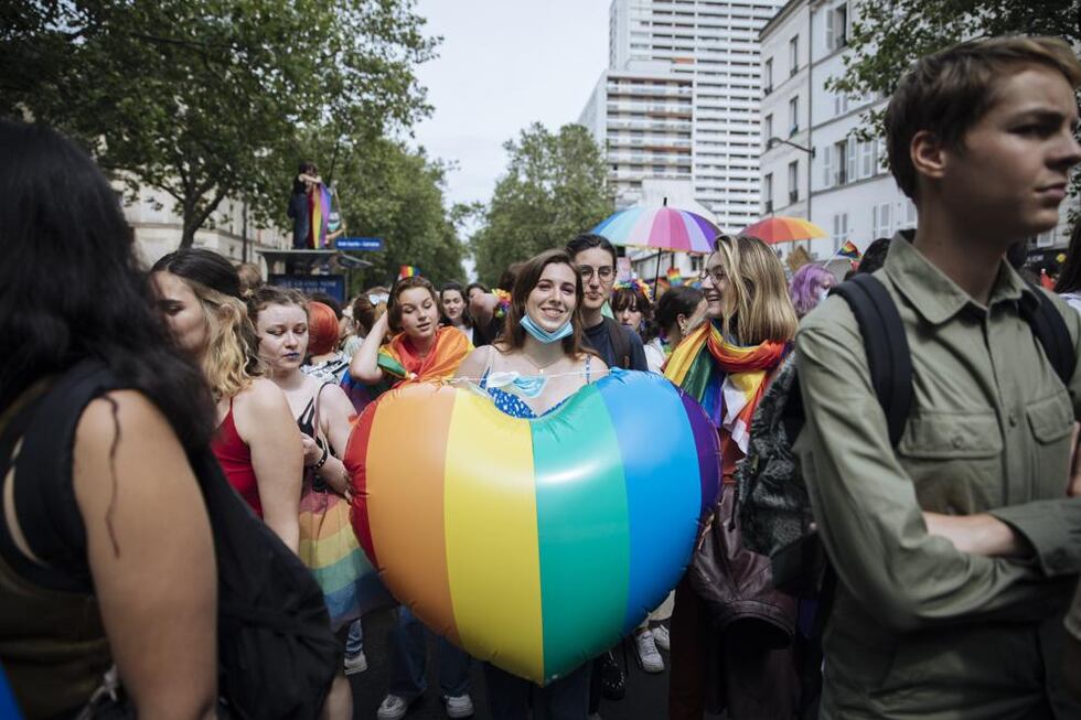 En esta imagen de archivo, una participante sostiene un corazón con la bandera arcoiris...