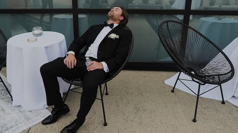 ARCHIVO - Un padrino de boda se toma un descanso después de concluir las fotos de la fiesta...